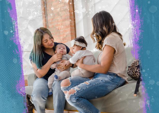 Two moms holding their babies in their laps and sitting next to each other