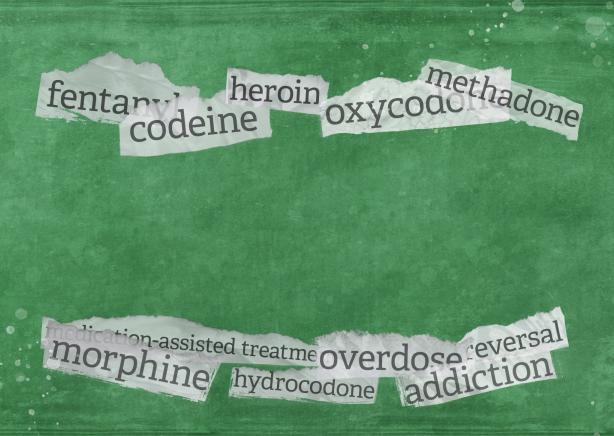 A green background with strips of paper containing words related to opioids. Some of the words include "fentanyl, morphine, addiction, and methadone.