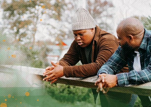 father and son leaning on a railing and talking with each other