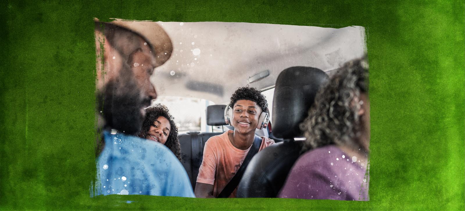 Two parents riding in a car talking to their two children in the back seat.