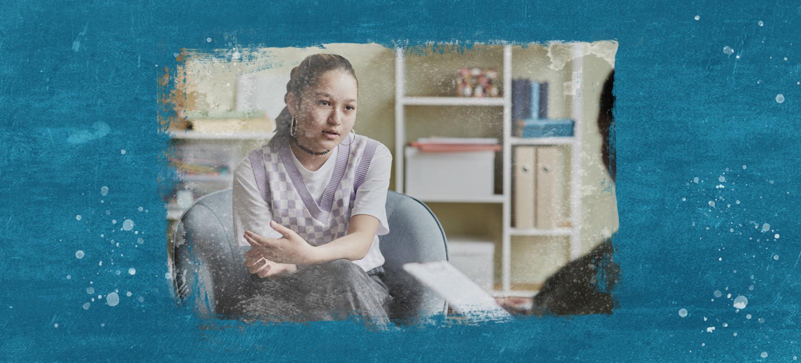 A teen girl sitting in a chair talking to a therapist. She has dark hair in a braid, a choker necklace, and is wearing a lavender checkered vest over a white t-shirt.