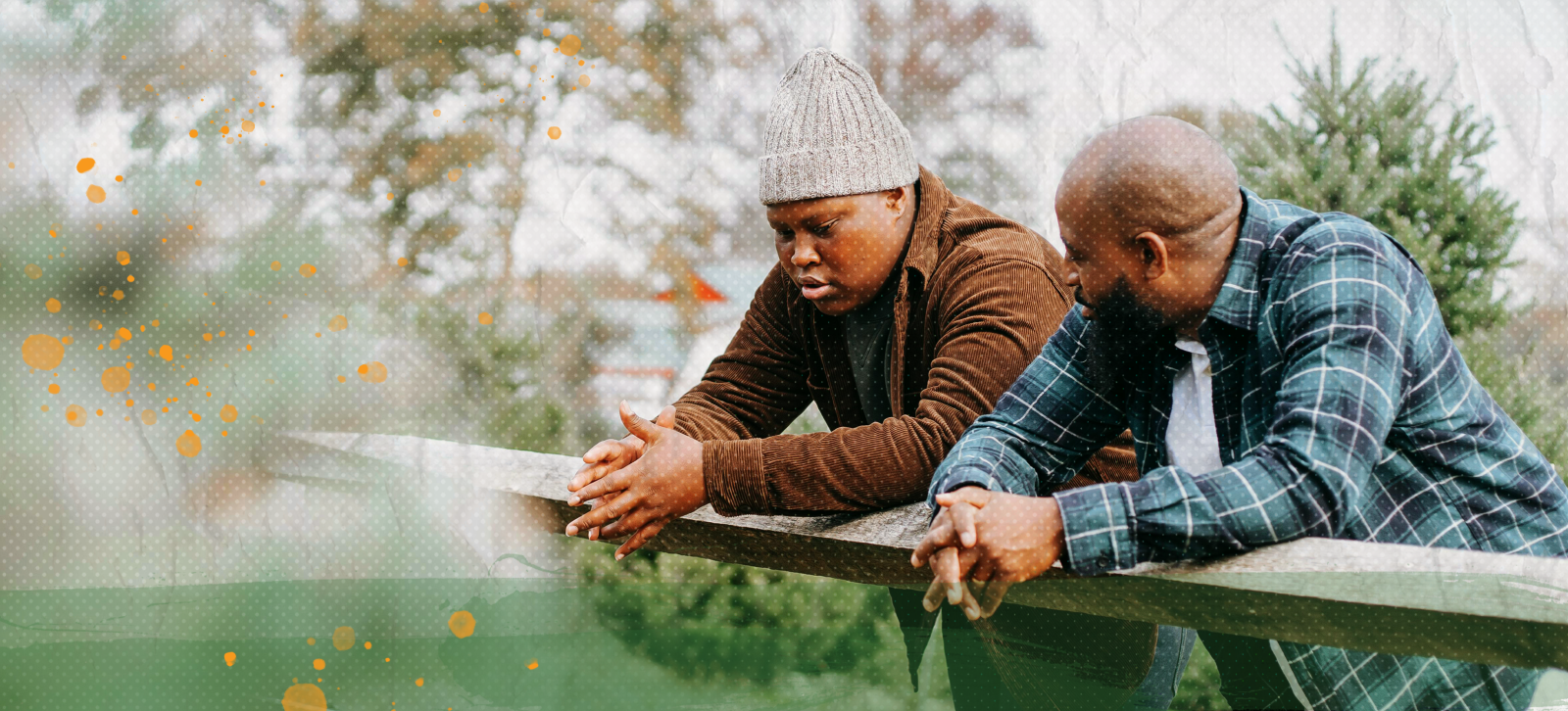 Father and son leaning on a railing and talking with each other.