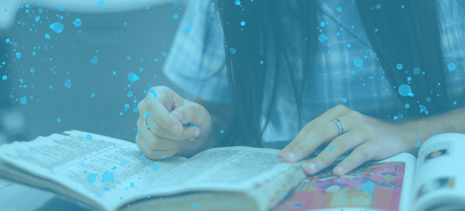 A girl with long black hair reading a book