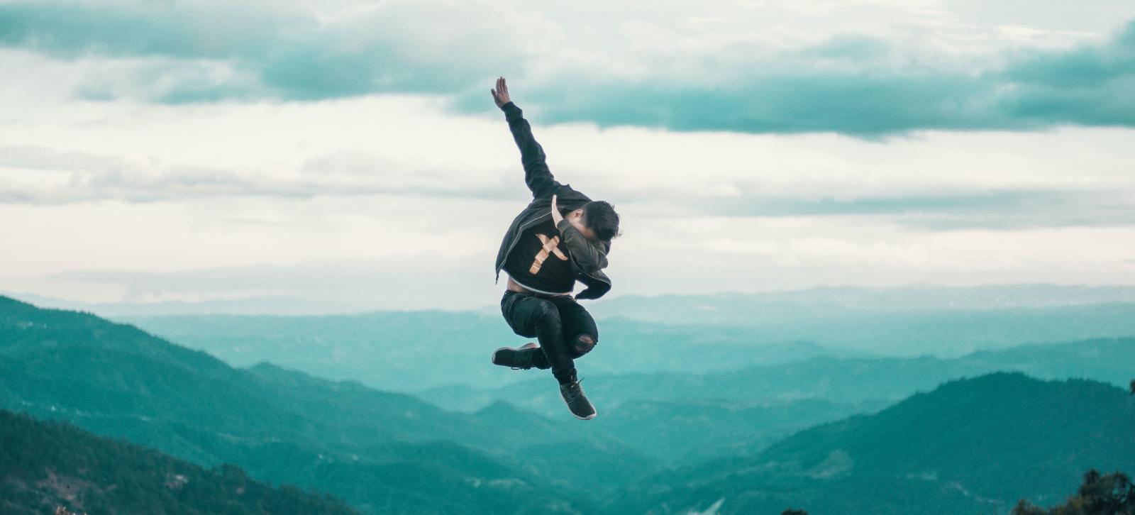 Man jumping in the air and dabbing.
